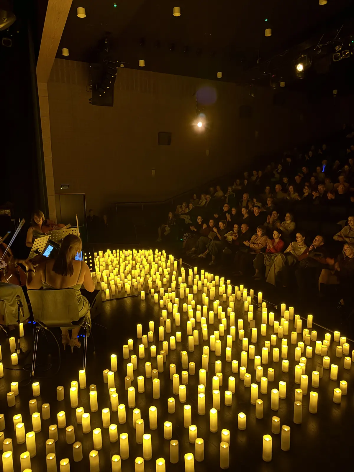 Świece układają się w ścieżkę przez scenę. Koncert przy świecach w Kozienicach, 16.04.2026